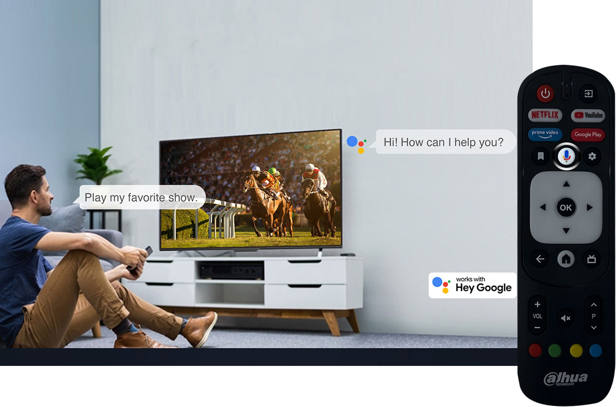 Άντρας που κάθεται στο πάτωμα μπροστά από την Dahua τηλεόραση, δίνει φωνητικές μέσω Google Assistant